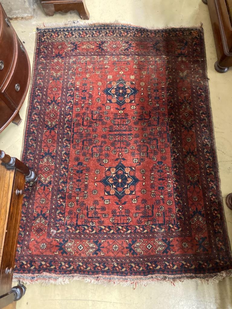 An Afghan red ground rug, 142 x 103cm